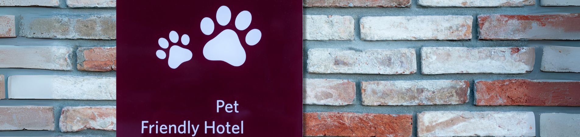 Mur en brique avec panneau : "Pet Friendly Hotel"